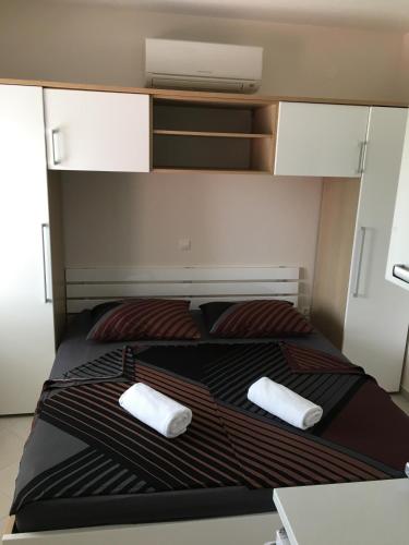 a bed with two pillows on top of it at Apartments Villa Jennifer in Orebić