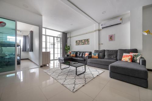 a living room with a couch and a table at MIQ HK611 Huai Khwang 4BR Jodd fair in Bangkok
