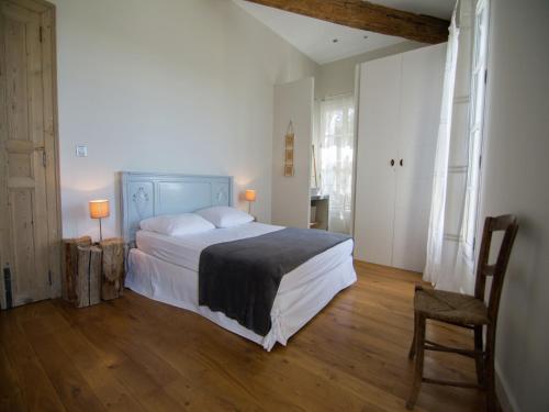 een slaapkamer met een groot bed en een stoel bij Holiday Home in Hérault with Pool in Campagnan