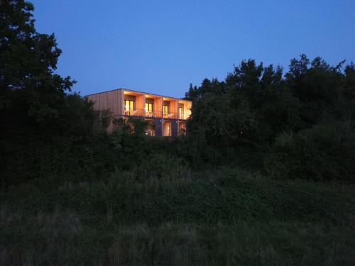 a building on top of a hill at night at NEU Feinzeit Natur Lofts - Klima, Sauna, Design in Frensdorf