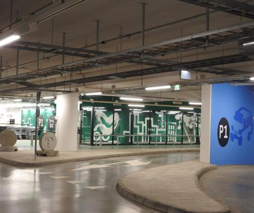 an empty parking garage with graffiti on the walls at Mall of Tripla apartments by Come in! in Helsinki