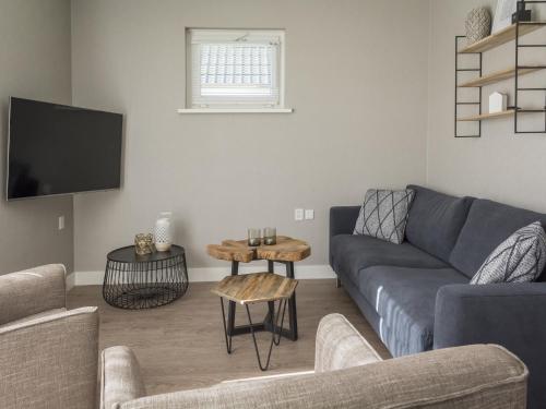 デ・カクスドルプにあるBungalow on Texel with a spacious terraceのソファとテーブルのあるリビングルーム