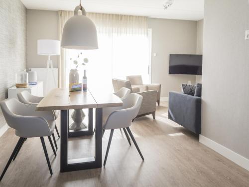 デ・カクスドルプにあるBungalow on Texel with a spacious terraceのリビングルーム(ダイニングテーブル、椅子付)