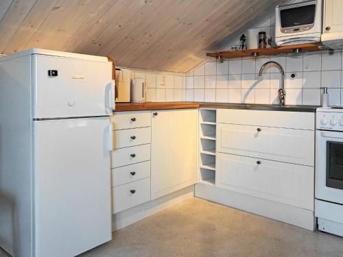 a white kitchen with a sink and a refrigerator at 4 person holiday home in ELLÖS in Ellos