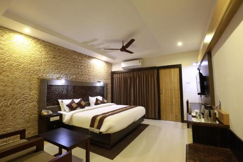a bedroom with a king sized bed in a room at Hotel Mayas in Tiruchchirāppalli