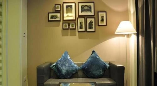 a living room with a couch with two blue pillows at Jinjiang Metropolo Hotel Classiq YMCA People Square in Shanghai