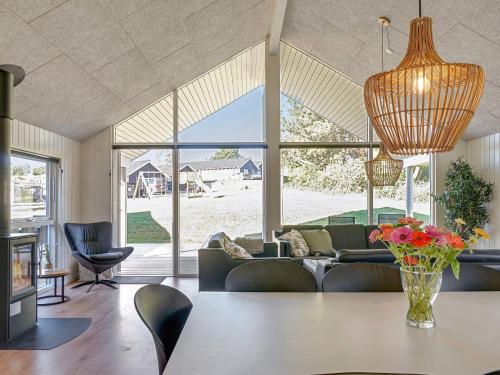a living room with a table with a vase of flowers at 14 person holiday home in Vejby in Vejby
