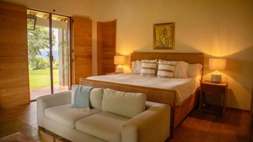 CoapanにあるRancho El Salto, Villa with Private Pool and Viewsのベッドとソファと窓のある寝室