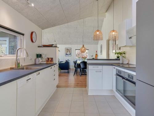a kitchen with white cabinets and a dining room at 14 person holiday home in Vejby in Vejby