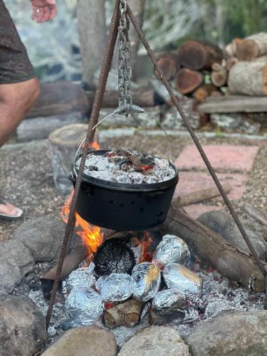 a pot on top of a camp fire at The Archer Retreat in Villeneuve