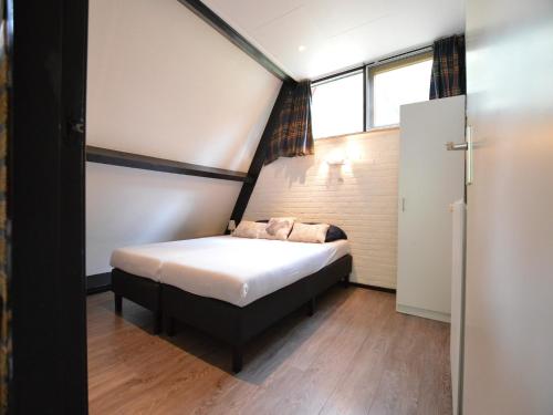 a small bed in a room with a window at Pet-Friendly Getaway in Stramproy