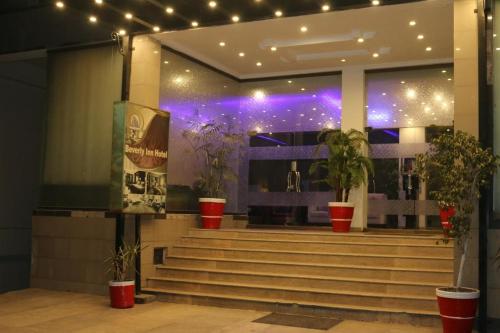 a building with stairs and potted plants and lights at Airport view hotel in Lahore