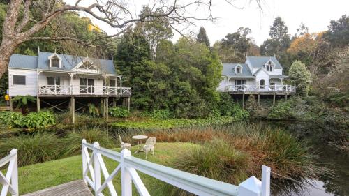 two large white houses on the side of a river at Apple Tree Cottage in Apollo Bay