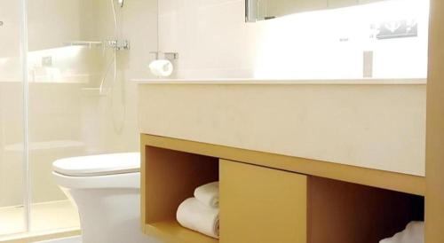 a bathroom with a toilet and a counter with a sink at City Comfort Inn Wuhan Wansongyuan Wangjiadun East Metro in Wuhan