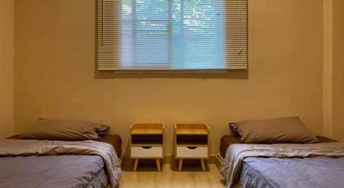 a room with two twin beds and a window at THE GOOSE HOUSE UBON in Ubon Ratchathani