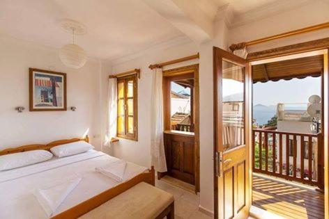 a bedroom with a bed and a balcony at The White House Kalkan in Kalkan