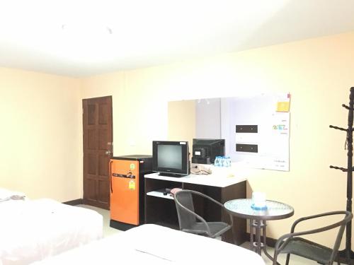 Zimmer mit einem Schreibtisch, einem Computer und einem Tisch in der Unterkunft The Star Villa Resort in Hat Yai