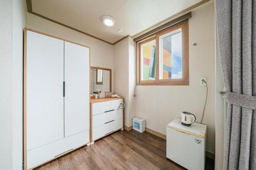 a bathroom with a white cabinet and a sink at Orange Hotel Jeju in Seogwipo