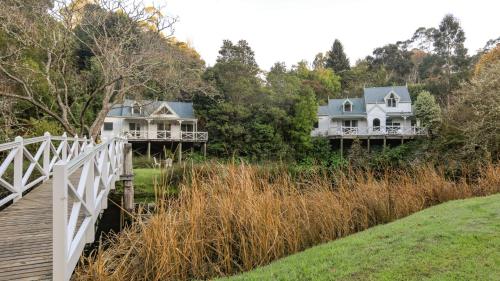 two houses on a hill next to a wooden bridge at Little Plum Cottage in Apollo Bay