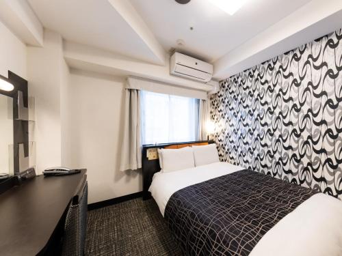 a hotel room with a bed and a desk at APA Hotel Kyoto Ekimae in Kyoto