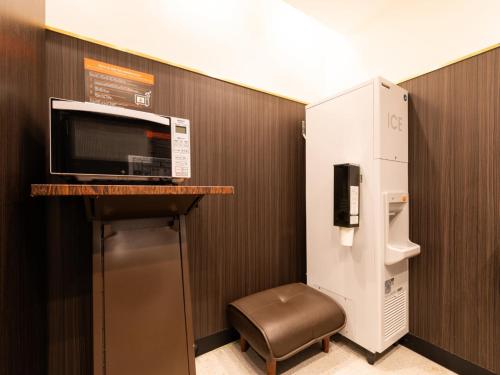 a room with a microwave and a refrigerator at APA Hotel Kyoto Ekimae in Kyoto
