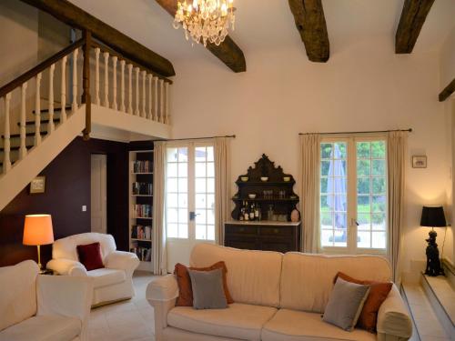 a living room with a white couch and a staircase at Luxury Villa in Dordogne with Pool & Privacy in Port-Sainte-Foy-et-Ponchapt
