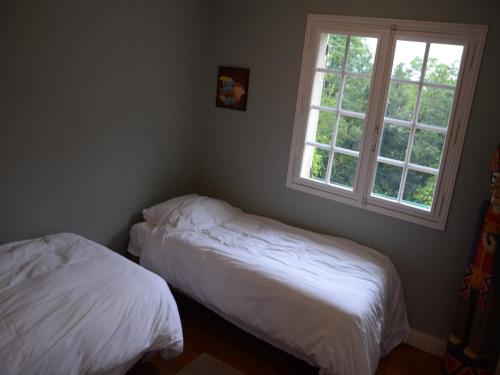 two beds in a room with two windows at Luxury Villa in Dordogne with Pool & Privacy in Port-Sainte-Foy-et-Ponchapt
