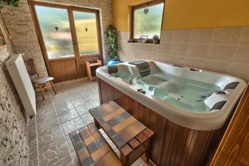 eine große Badewanne in einem Zimmer mit einem Tisch in der Unterkunft Penzion Havran in Ždiar