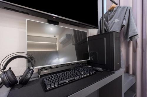 a computer monitor and a keyboard and headphones on a desk at Pohang Hotel La Terrace in Pohang