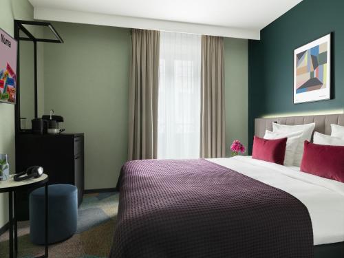 a bedroom with a large bed with red pillows at Numa Brussels Royal Galleries in Brussels