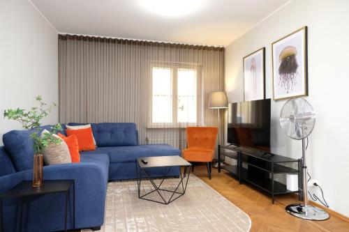 a living room with a blue couch and a tv at Tallinn City Apartments Old Town Toompea in Tallinn