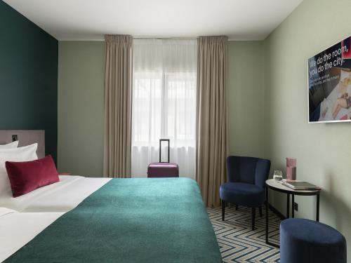 a hotel room with a bed and a chair at Numa Brussels Royal Galleries in Brussels