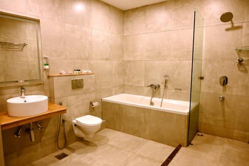 a bathroom with a tub and a toilet and a sink at Sia Signature Calangute in Calangute
