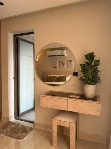 a dressing table with a mirror and a potted plant at Malath - The Bohemian Haven in Dammam