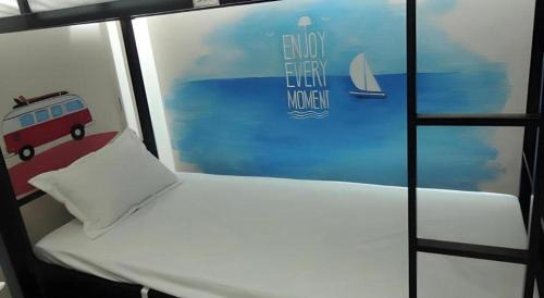 a room with a bed and a painting of a bus at Halong Happy Hostel in Ha Long