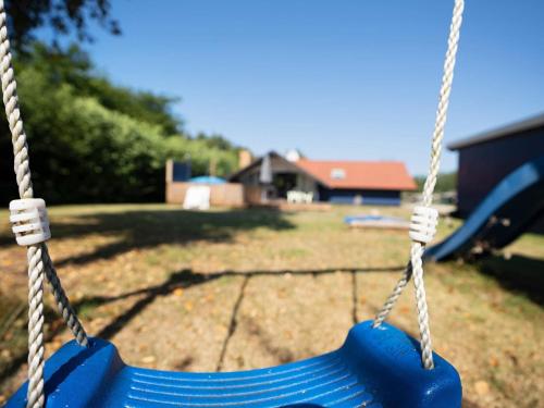 a blue swing in a yard with a playground at 5 person holiday home in Dannemare-By Traum in Dannemare