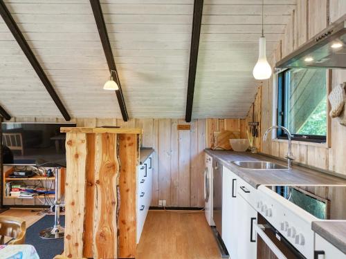 a kitchen with wooden walls and a counter with a sink at 5 person holiday home in Dannemare-By Traum in Dannemare