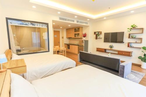 a living room with two beds and a television at FLC Sea Tower Quy Nhơn Seaview Apartment in Quy Nhon