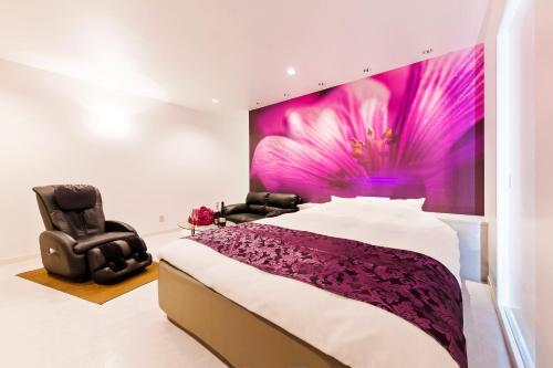 a bedroom with a large bed and a purple wall at HOTEL Lien in Ashiya