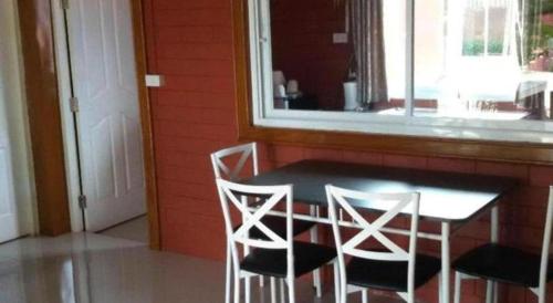 a dining room table with two chairs and a window at Lomdao Resort in Udon Thani