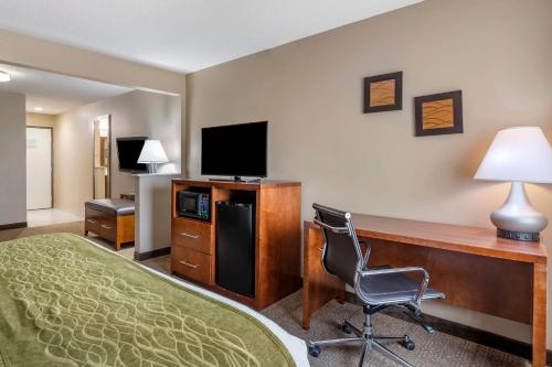 a hotel room with a desk with a computer and a chair at Comfort Inn Romeoville - Bolingbrook in Romeoville