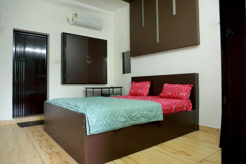 a bedroom with a bed with red pillows at Waterfall Gateway in Athirappilly