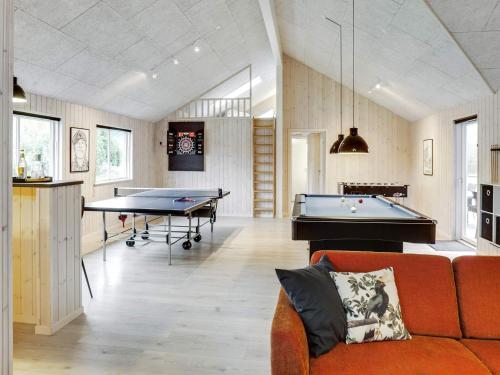 a living room with a couch and pool tables at 22 person holiday home in Idestrup in Marielyst