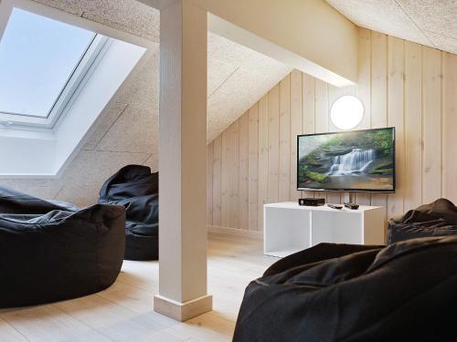 a living room with two black chairs and a television at 22 person holiday home in Idestrup in Marielyst