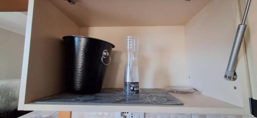 a black vase sitting on a shelf in a cabinet at Perla Blu Albania in Durrës