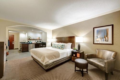 a hotel room with a bed and a chair at Garrison Hotel & Suites Dover-Portsmouth, an Ascend Collection Hotel in Dover