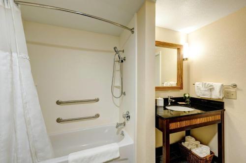 a bathroom with a shower and a sink at Garrison Hotel & Suites Dover-Portsmouth, an Ascend Collection Hotel in Dover