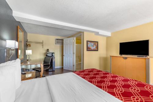 a hotel room with a bed and a flat screen tv at Econo Lodge Clovis in Clovis