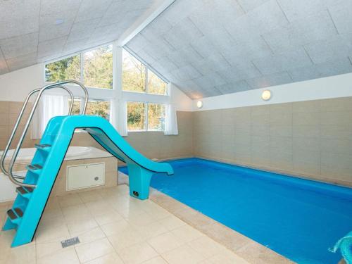 a swimming pool with a blue slide in a room at Luxury Pool Retreat in Henne - By Traum Ferienwohnungen in Henne Strand
