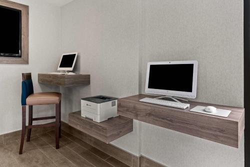 a desk with a computer and a monitor and a chair at Comfort Inn & Suites Beaverton - Portland West in Beaverton